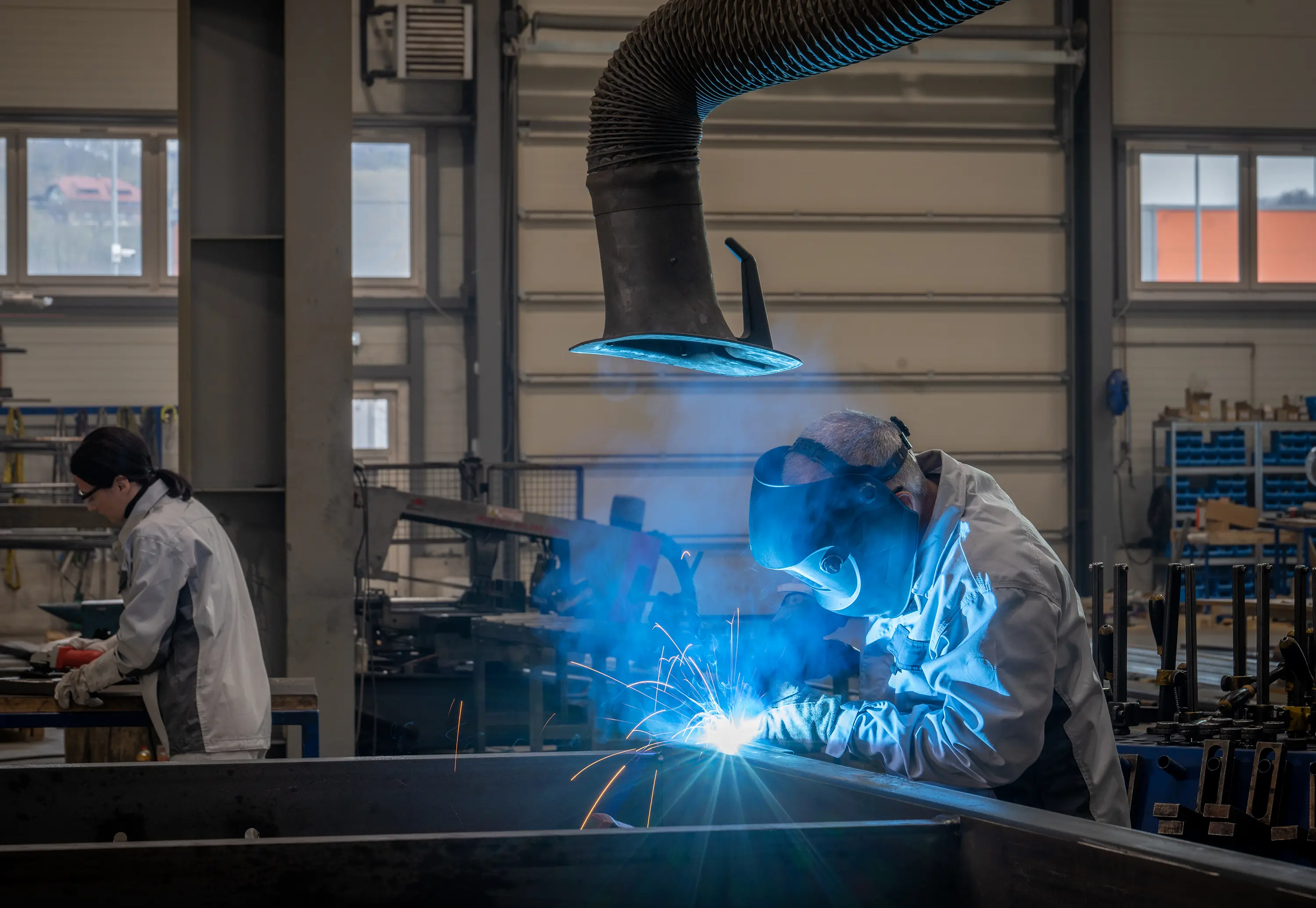 man welding under fume extractor vent